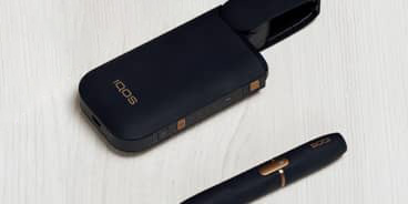 Black IQOS 2.4 Plus charger and holder on a table