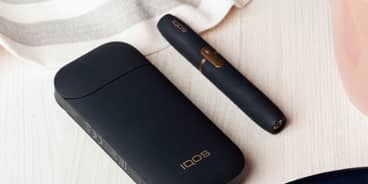 Black IQOS 2.4 Plus charger and holder on a table