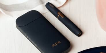 Black IQOS 2.4 Plus charger and holder on a table