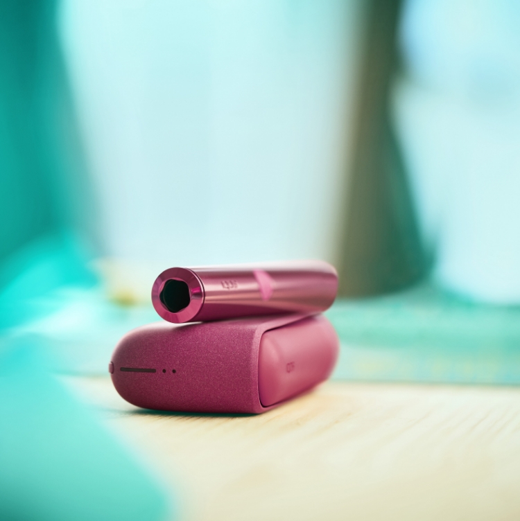 A Sunset Red IQOS ILUMA Pocket Charger and Holder.